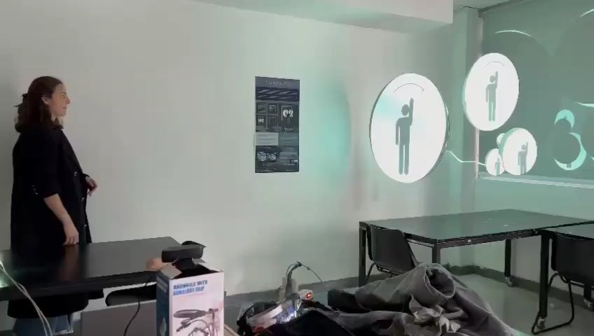A person approaching the wall while the circles show a pictogram of a raised hand